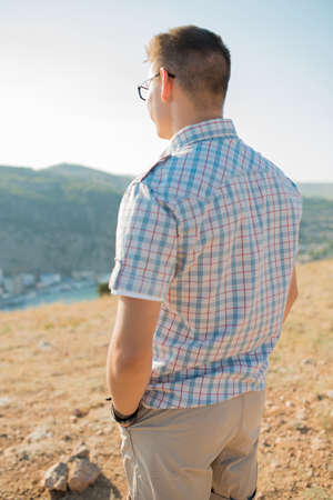 portrait of the young man. dressed in a plaid shirt, hands I thrust into pockets. summer. sun. restの写真素材