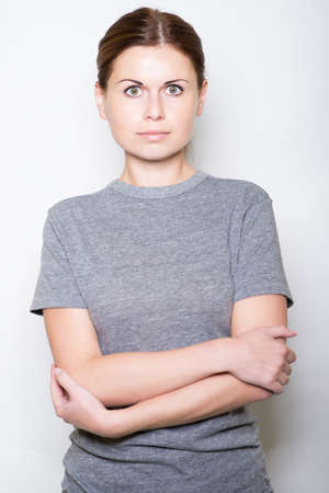 beautiful young woman crossed hands and looks in the cameraの写真素材