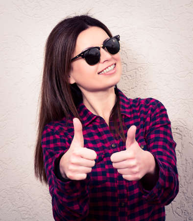 Portrait of a  blond beautiful woman with thumbs up. hipsterの写真素材