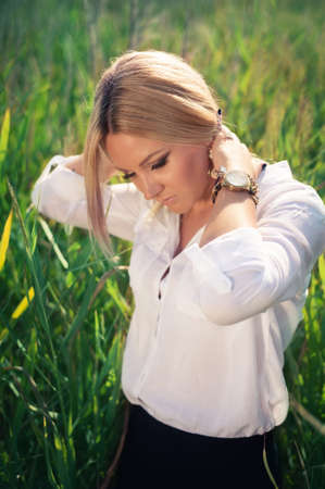 young beautiful woman poses in green thickets, looks in the camera. fashion modelの写真素材