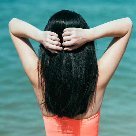 Woman rest on a beach. Portrait of the beautiful girl close-up, the wind fluttering hair.の写真素材