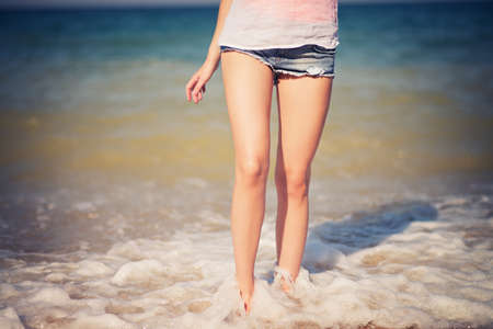 Female leg walking on the beach in the ocean. の写真素材
