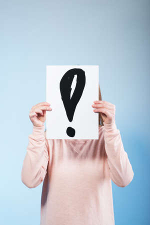 Young woman holding a cardboard with exclamation mark