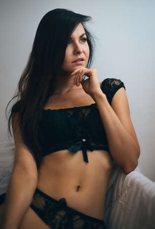 young girl, the beautiful brunette poses in black underwear, bewitches the sexual look. Vogue styleの写真素材