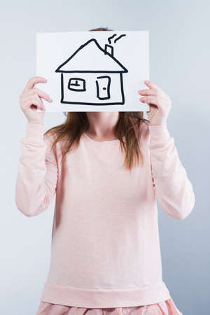 young woman holding picture with houseの写真素材