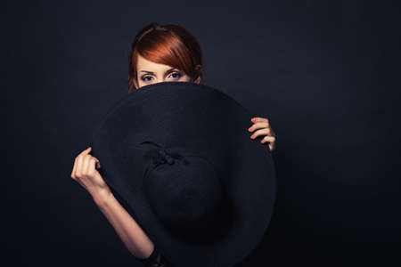 Portrait of a very beautiful girl in black dress and hat. Vogue styleの写真素材