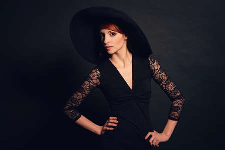 Portrait of a very beautiful girl in black dress and hat. Vogue styleの写真素材