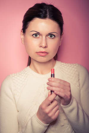 portrait of young woman applying lips make up.  Vogue styleの写真素材