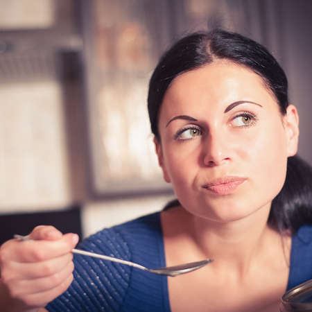 Young housewife cooks food in kitchen. Soup. Dinnerの写真素材