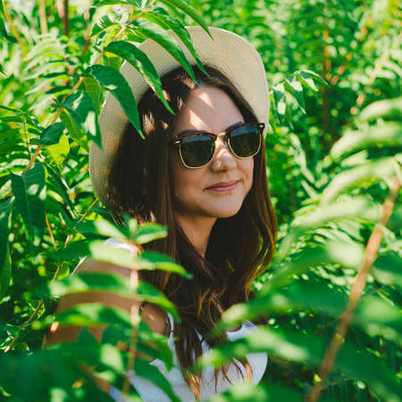 Beautiful young woman in stylish hat and jeans shorts posing. Hipster styleの写真素材