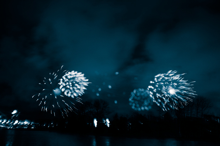Abstract, blurry, bokeh-style colorful photo of fireworks above the river in New Yearの写真素材