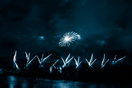 Abstract, blurry, bokeh-style colorful photo of fireworks above the river in New Yearの写真素材