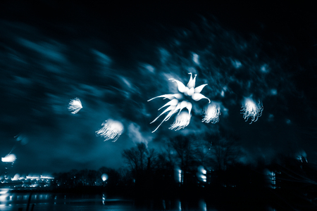 Abstract, blurry, bokeh-style colorful photo of fireworks above the river in New Yearの写真素材