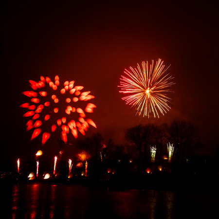 Abstract, blurry, bokeh-style colorful photo of fireworks above the river in New Yearの写真素材