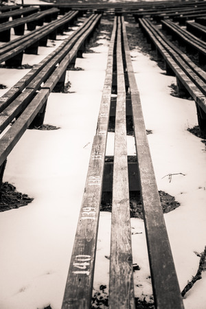 A beautiful monochrome pattern of wooden benches in rowsの写真素材