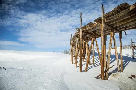 An old, abandoned copper mine building in the snowy Norway landscapeの写真素材