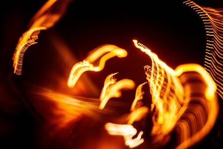 Red abstract trails of light on dark background. Long exposure.の写真素材