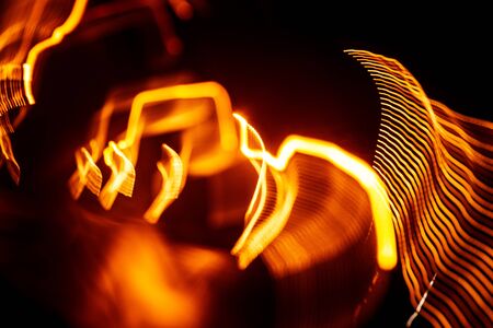Red abstract trails of light on dark background. Long exposure.の写真素材