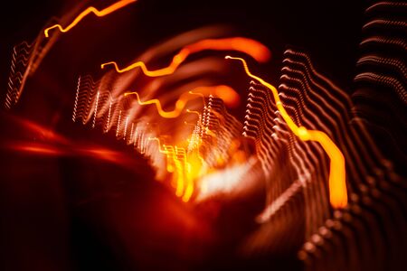 Red abstract trails of light on dark background. Long exposure.の写真素材