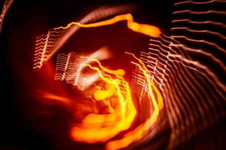 Red abstract trails of light on dark background. Long exposure.