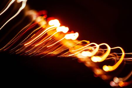 Red abstract trails of light on dark background. Long exposure.の写真素材