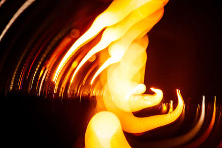 Red abstract trails of light on dark background. Long exposure.の写真素材