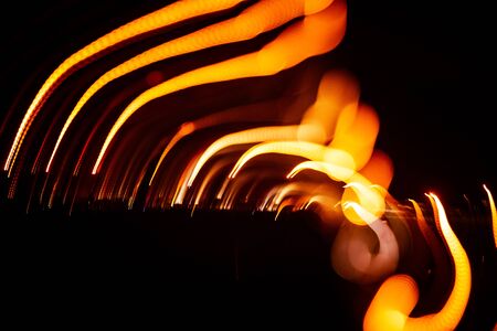 Red abstract trails of light on dark background. Long exposure.の写真素材