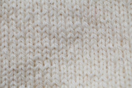 A beautiful closeup of a hand knitted warm and soft wool pattern. Soft socks or scarf of natural...