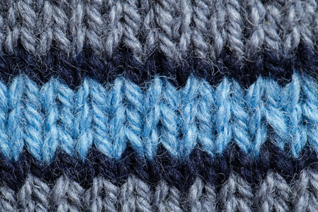 A beautiful closeup of a hand knitted warm and soft wool pattern. Soft socks or scarf of natural...