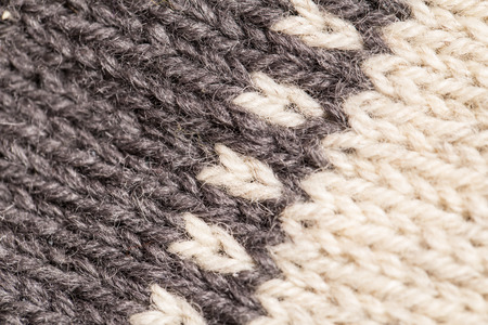 A beautiful closeup of a hand knitted warm and soft wool pattern. Soft socks or scarf of natural...