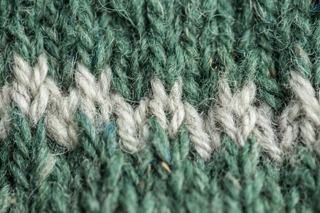 A beautiful closeup of a hand knitted warm and soft wool pattern. Soft socks or scarf of natural...