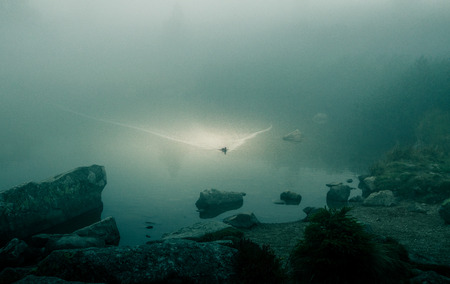 A beautiful mountain lake in a fog in Tatry, Slovakia. Low saturation retro styleの写真素材
