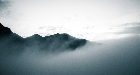 A beautiful monochromatic mountain view with rising clouds