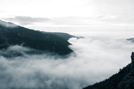 A beautiful monochromatic mountain view with rising clouds