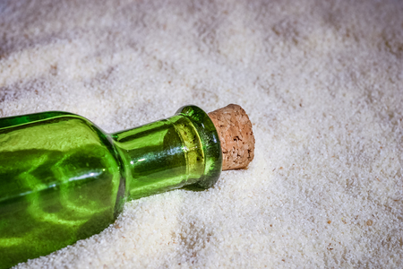 A beautiful green bottle in the sandの写真素材