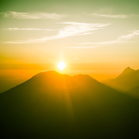A beautiful, colorful, abstract mountain landscape with a hot summer haze in warm green tonality. Decorative, artistic look.の写真素材