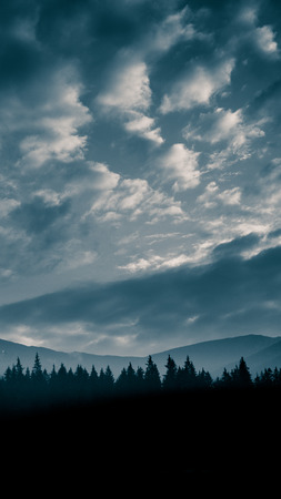 An inspiring mountain landscape in Tatry, Slovakia. Vivid, gradient scenery with perspective in blue tone. Summer in mountains. Nature wallpaper in bright colors. A beautiful vertical wallpaper for a smartphone. Vertical image for a mobile use.の写真素材