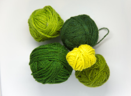 Small colorful ball of wool yarn on a white background. Hand craft supplies.