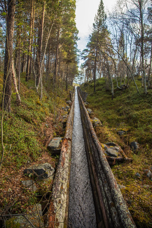 A beautiful autumn scenery of a historic water channel for transporting timber between lakes. Wooden construction.  Autumn in Femundsmarka National Park.の写真素材