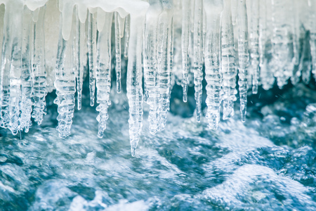 A beautiful frozen icicles at the bank of river in Latvia. Beautiful winter scenery.