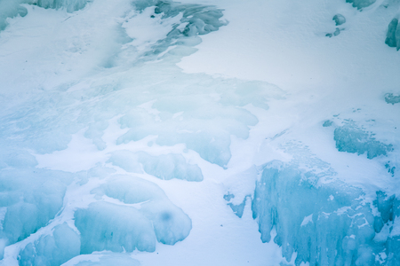 Beautiful frozen waterfall in central Norway. Winter landscape with a frozen river and ice...
