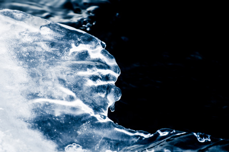 A beautiful monochrome closeup of an ice formations on the bank of river in winter. Abstract blue background.の写真素材