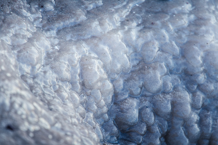 A beautiful closeup of a frozen sea water on the coast of Baltic sea. Frozen salt water vawes on a beach. Abstract closup of ice.の写真素材