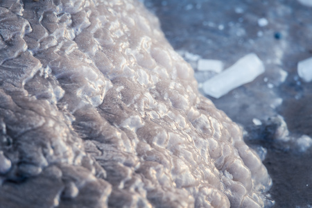 A beautiful closeup of a frozen sea water on the coast of Baltic sea. Frozen salt water vawes on a beach. Abstract closup of ice.の写真素材