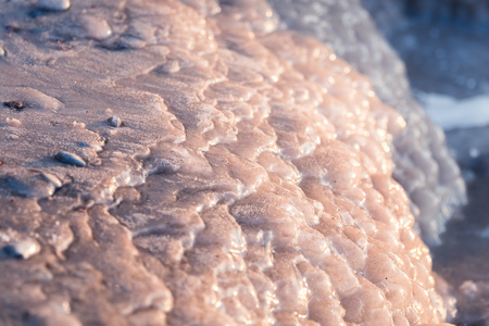 A beautiful closeup of a frozen sea water on the coast of Baltic sea. Frozen salt water vawes on a...