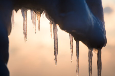 A beautiful hangign icicles of salt water on the coast of Baltic sea. Ice in the beach at winter. Frozen water formations.の写真素材
