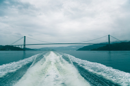 A dramatic, overcast scenery on the coeast of fjord during a ferry ride in Norway near Bergen. Moody autumn landscape of fjord.の写真素材
