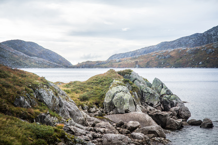 A beautiful landscape of a mountain lake in Folgefonna National Park in Norway. Overcast autumn day in mountains. Autumn scenery of lake.の写真素材
