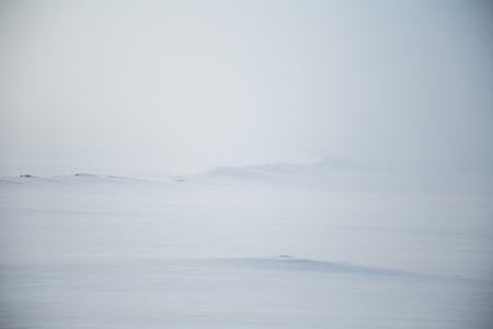 A beautiful, misty morning in the Norwegian hills in winter. White, hazy landscape. Near the small Norwegian town Roros.の写真素材