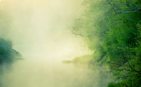 A beautiful river morning with mist and sun light. Springtime scenery of river banks in Northern Europe. Warm, colorful look.の写真素材